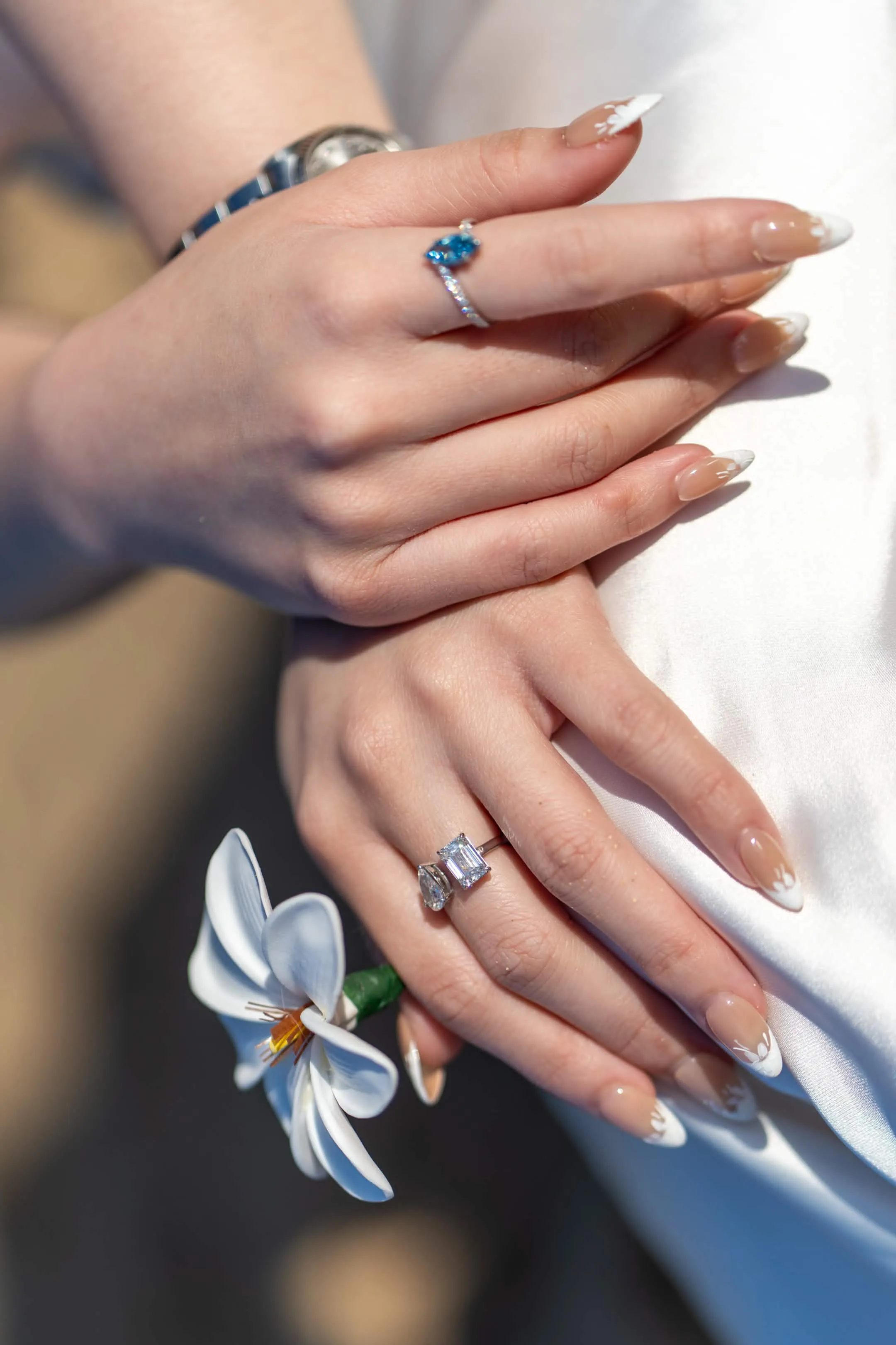 Close-up of diamond rings and a plumeria flower